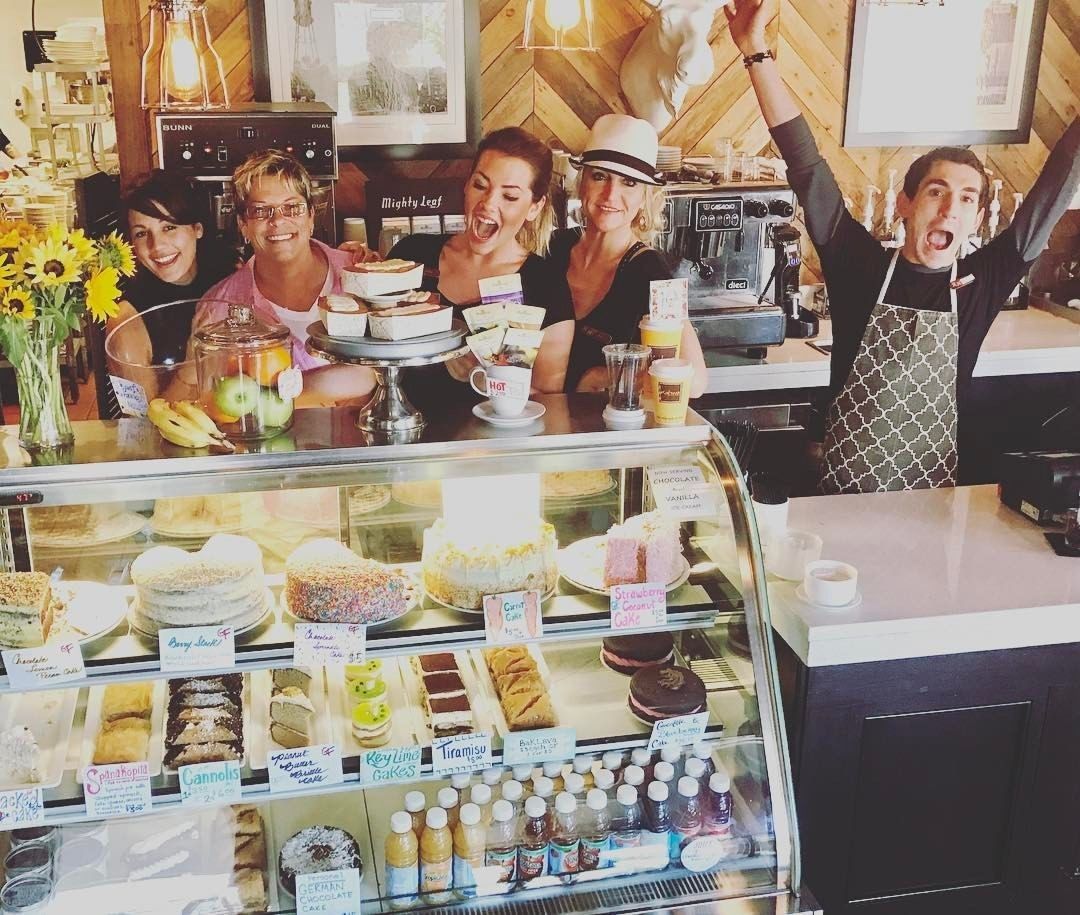 Mostrador de panadería con diferentes productos horneados y una máquina de café.