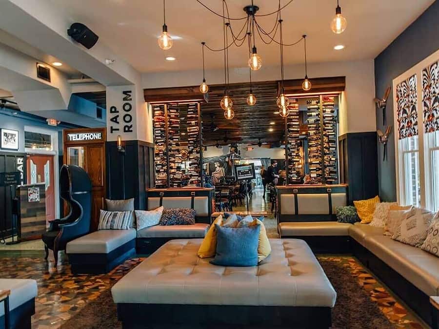 Un espace de détente moderne, doté de sièges, d’une cabine téléphonique et d’un mur orné de motifs décoratifs.