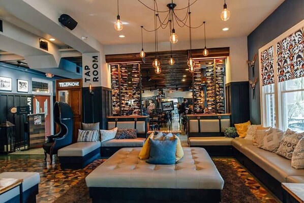 A modern lounge area with seating, a telephone booth, and a wall with patterned decorations.
