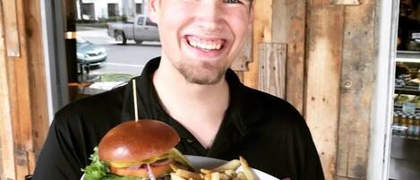 Une personne tenant une assiette avec un hamburger et des frites.