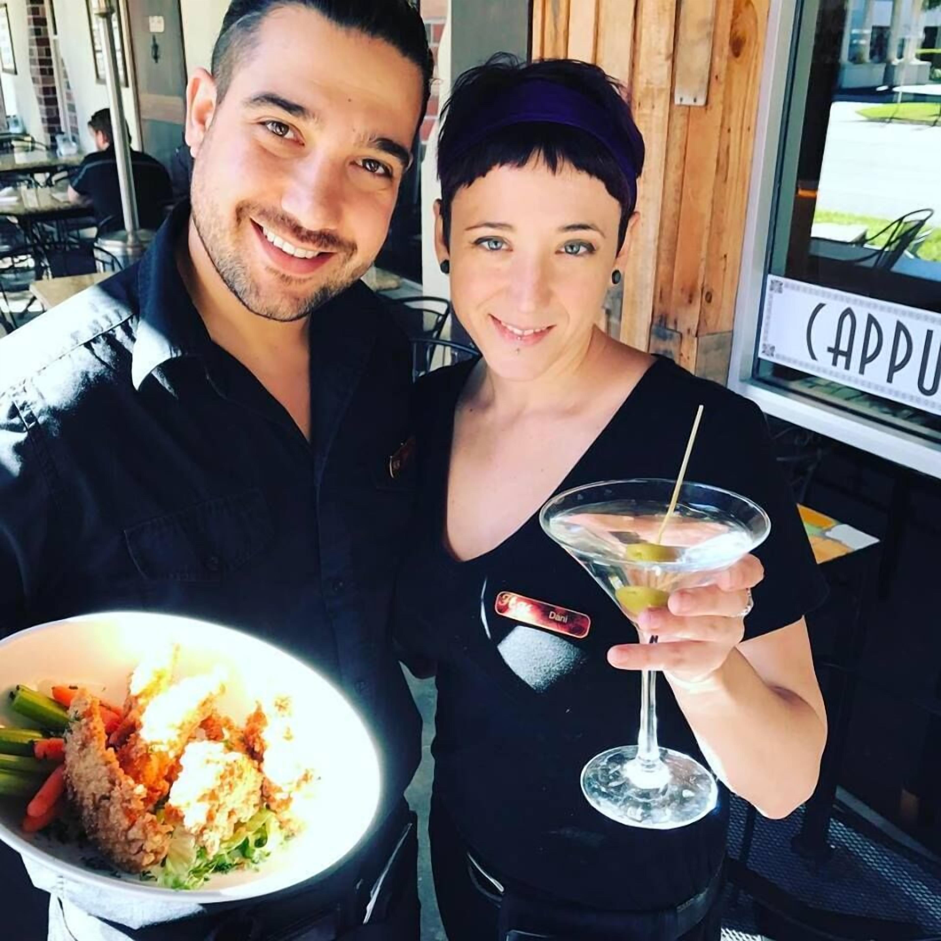 A person holding a plate of food and a drink.