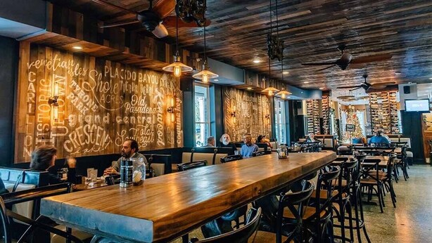 A restaurant with wooden ceiling and walls, hanging pendant lights, and a long wooden bar. - Hollander Boutique Hotel (St. Petersburg)