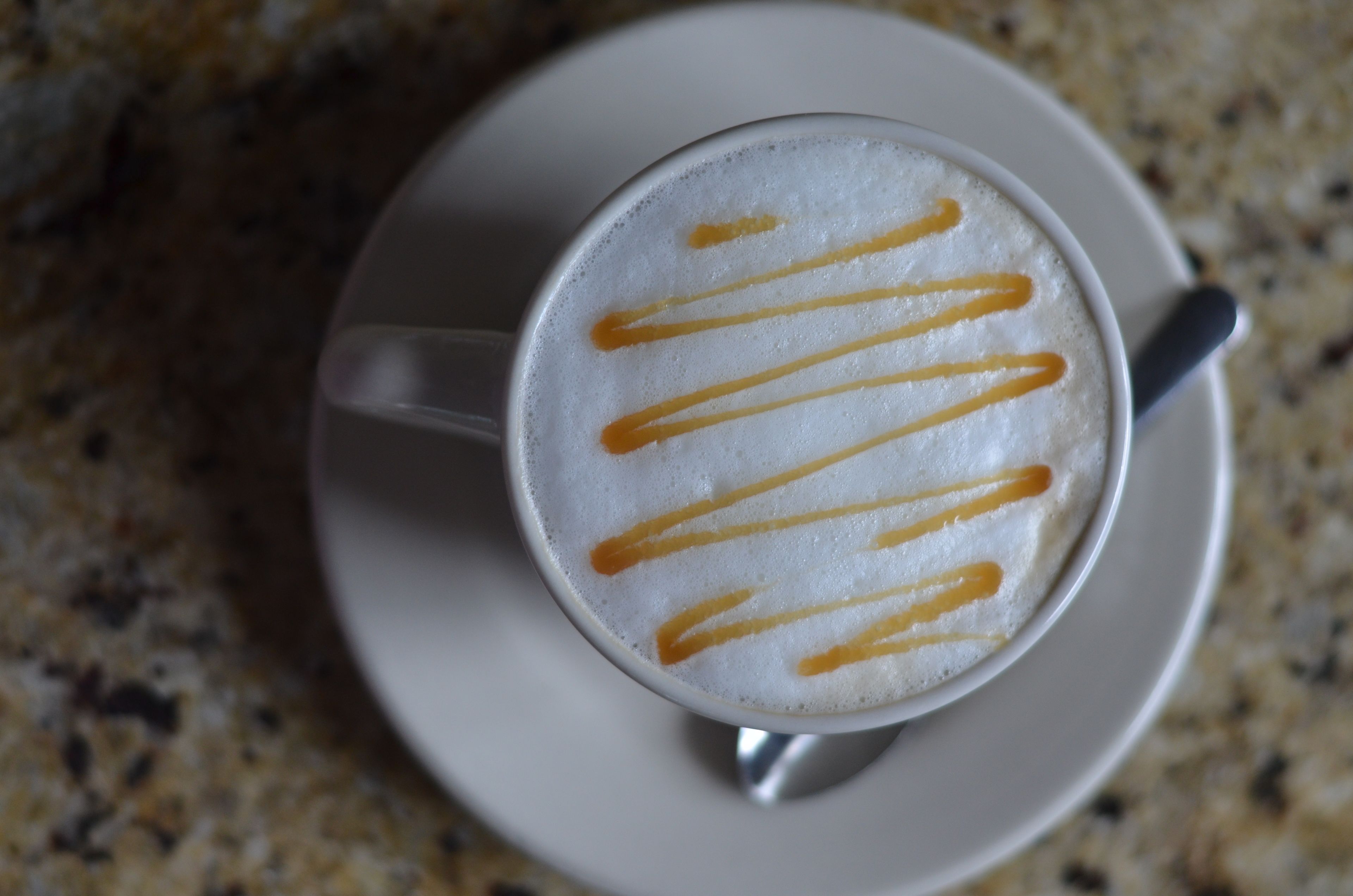 Una taza de café con arte de latte en un plato.