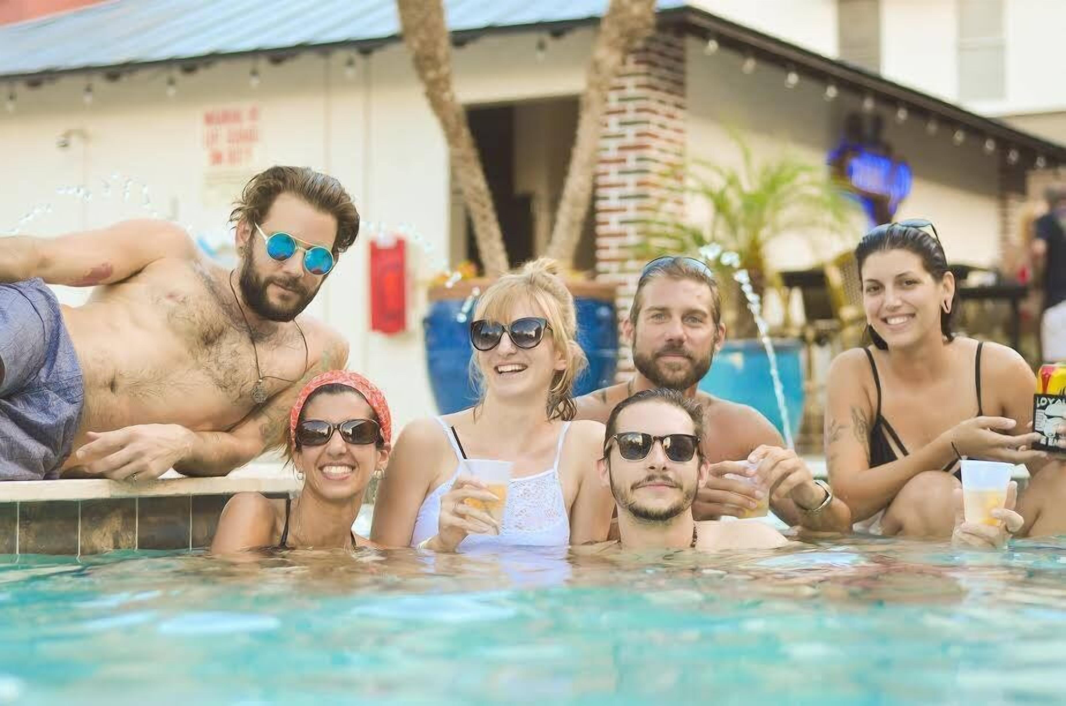 A group of people in a swimming pool with a building in the background.