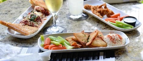 A meal with bread, vegetables, and a drink on a table with a menu.