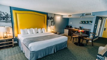 A hotel room with a large bed, a desk, and a chair.