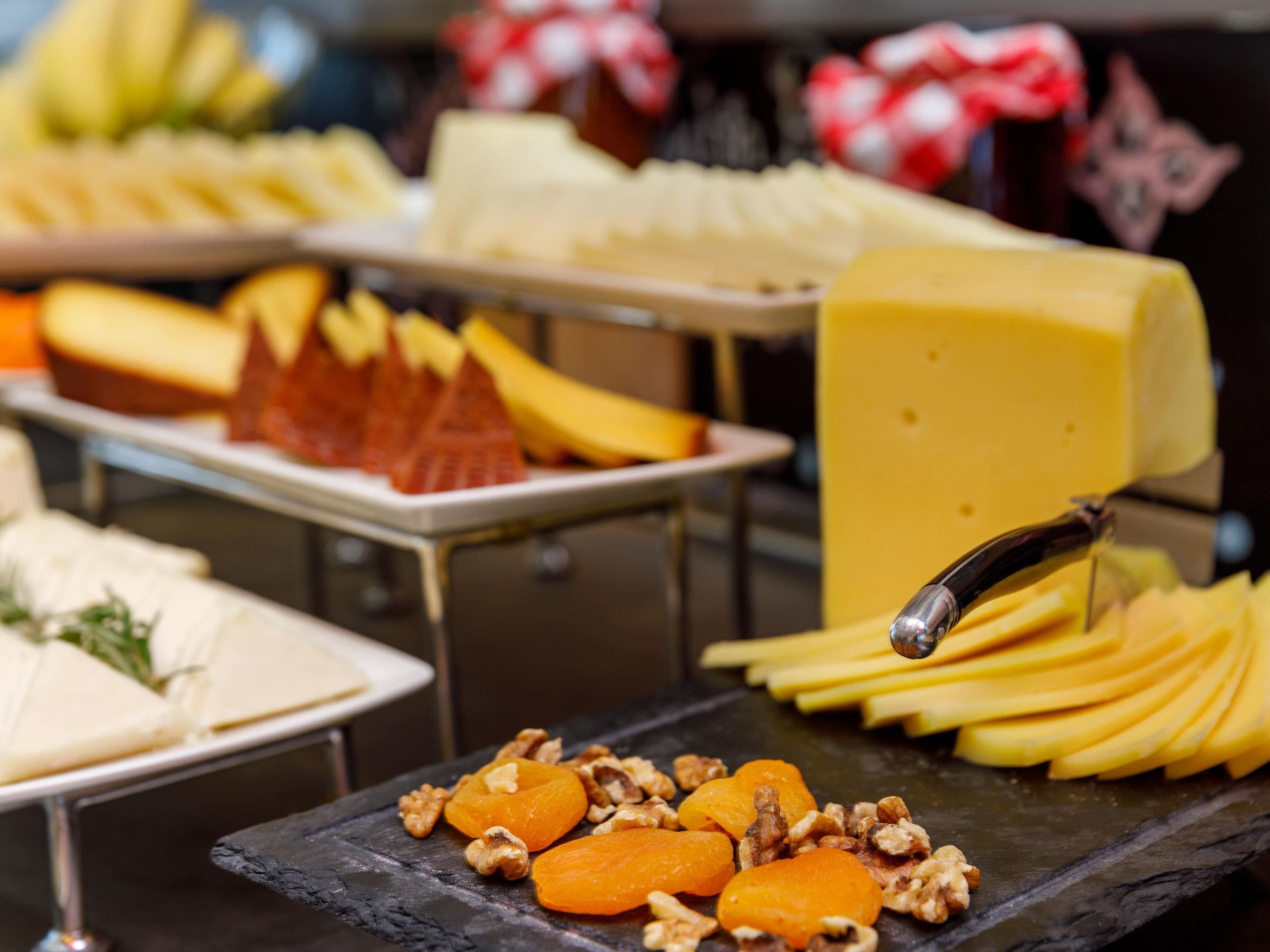 Une variété de fromages et de fruits sont exposés.
