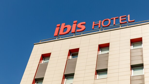 A hotel sign with the name "ibis HOTEL" against a clear blue sky. - ibis Istanbul Esenyurt (Istanbul)
