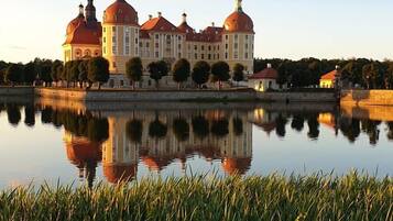 A large building with multiple domed roofs and a reflection in the water.