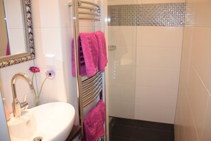 Studio | Badkamer | Een bad/douchecombinatie, een haardroger, handdoeken
