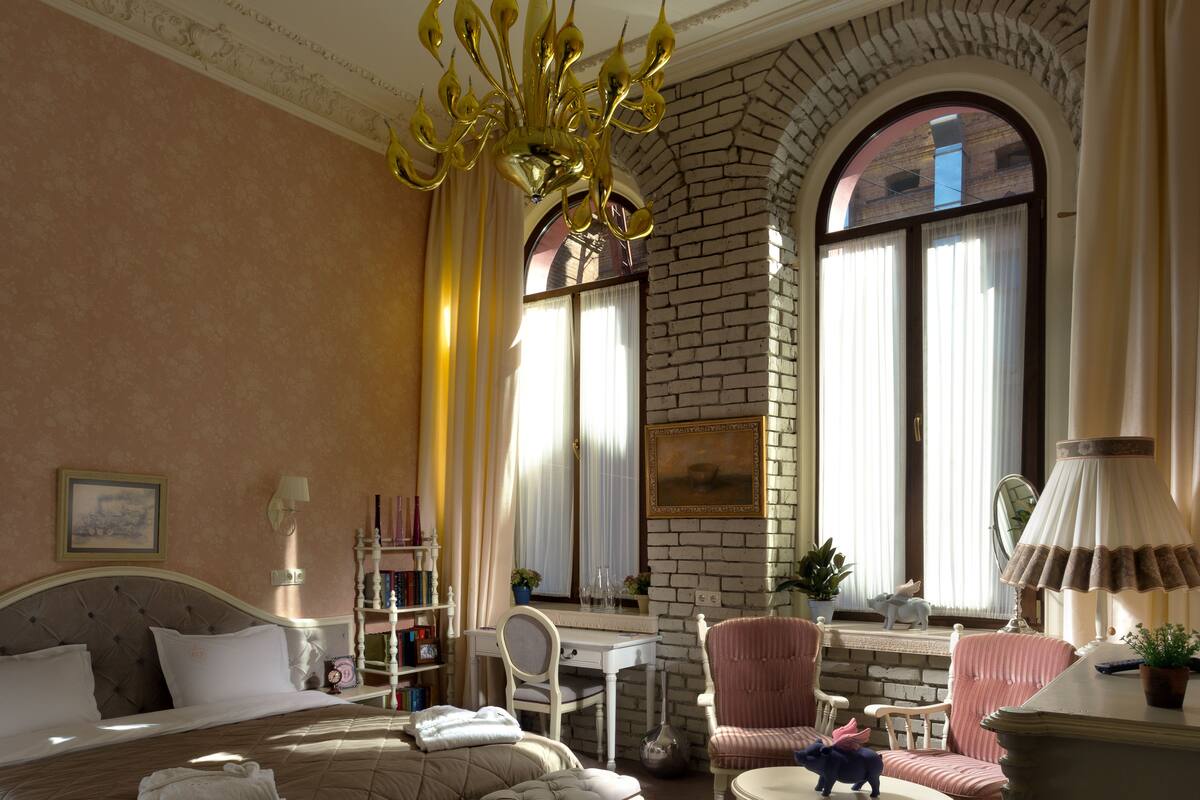 Una habitación de hotel con una cama grande, un escritorio, una silla y una mesita.