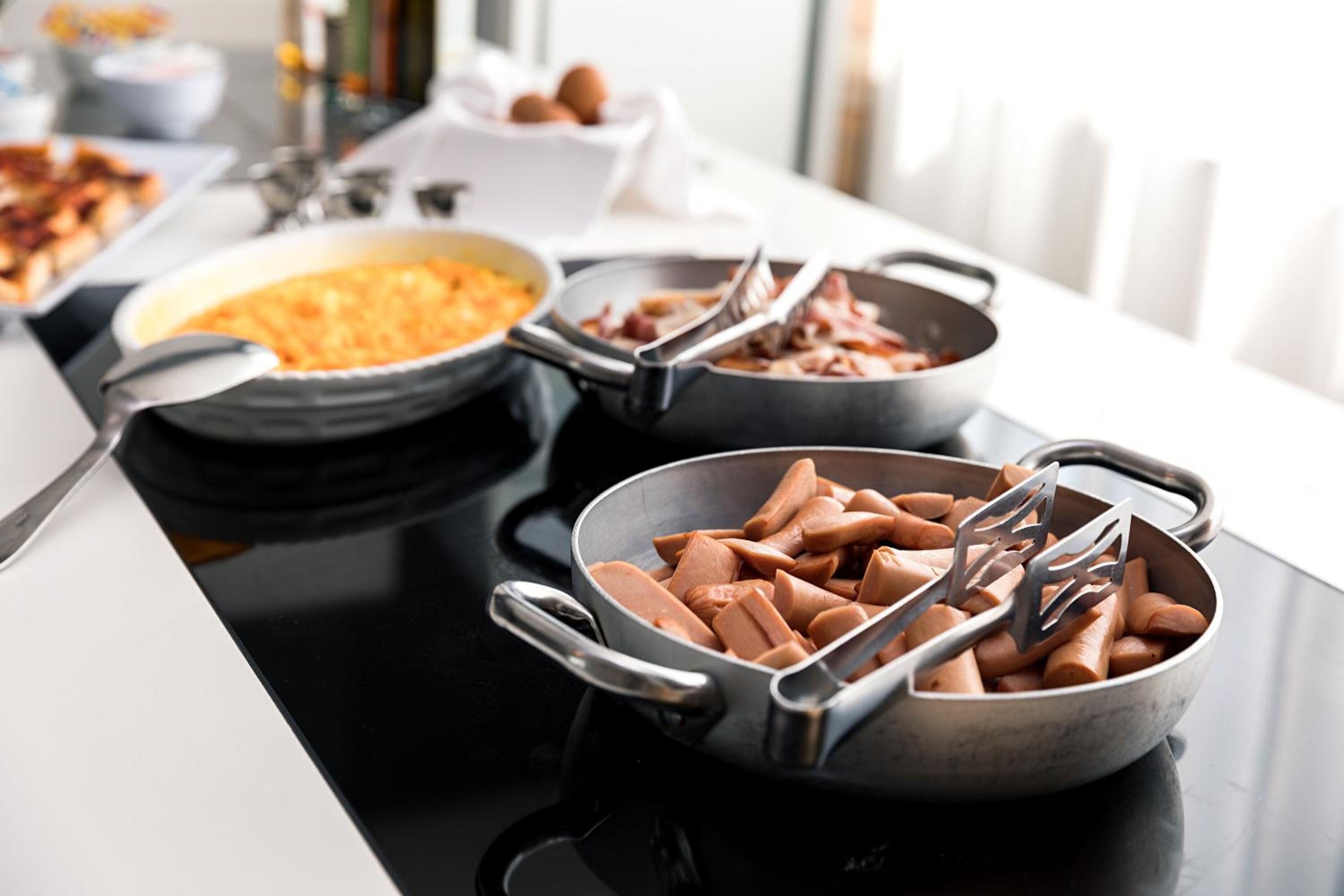 A kitchen counter with various cooking utensils and food items.