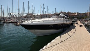 A marina with boats docked, a clear sky, and buildings in the background. - Une Nuit à Bord Bandol (Bandol)
