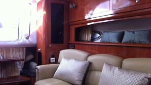 A cozy interior with a leather sofa, wooden cabinets, and a small table. - Une Nuit à Bord Bandol (Bandol)