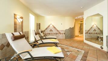 A spa area with reclining chairs, a tiled floor, and a wall with a geometric pattern.