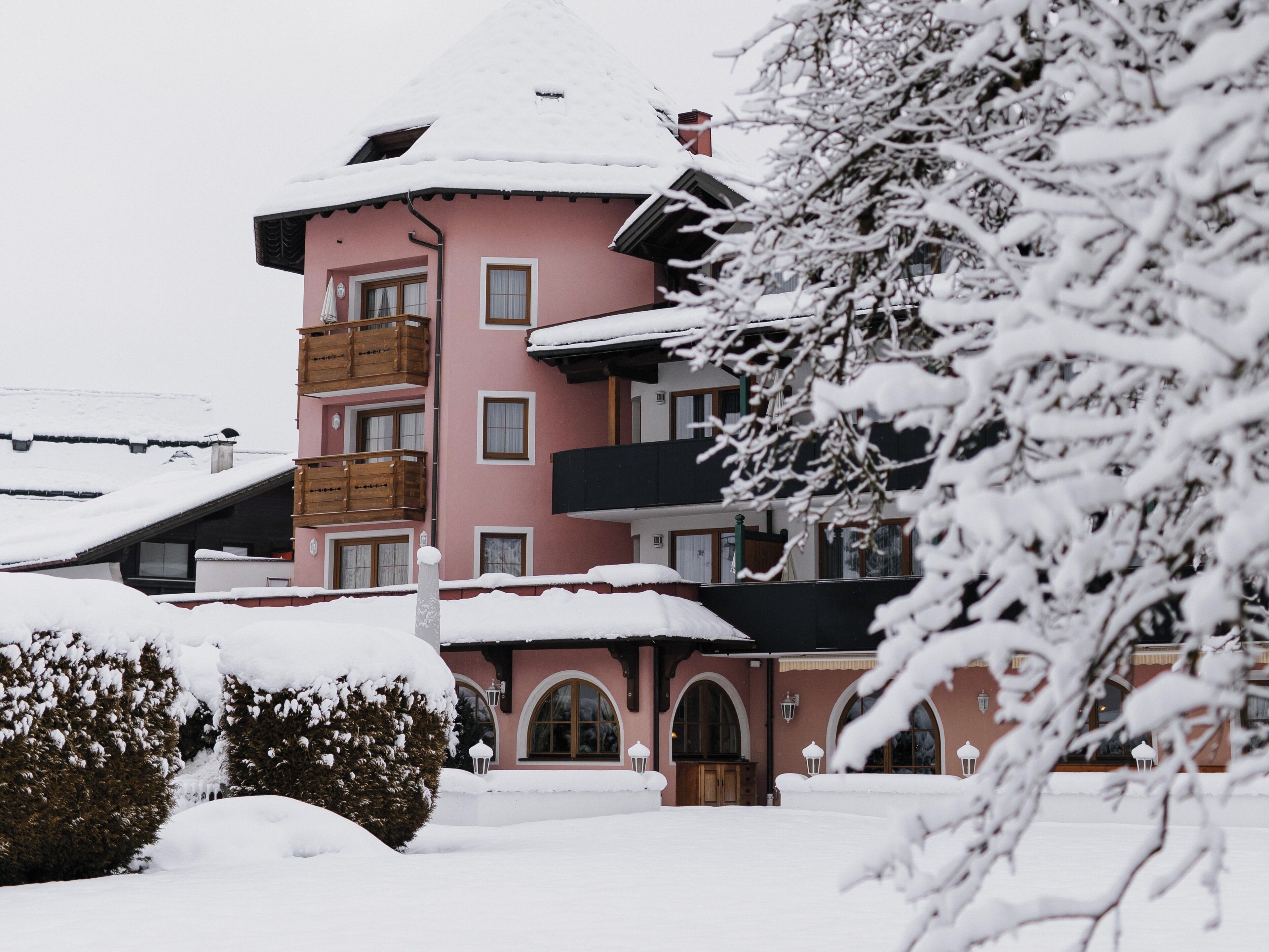 A multi-story building with balconies and a snow-covered roof.