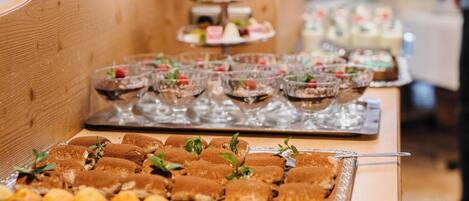 A buffet table with various desserts and pastries.