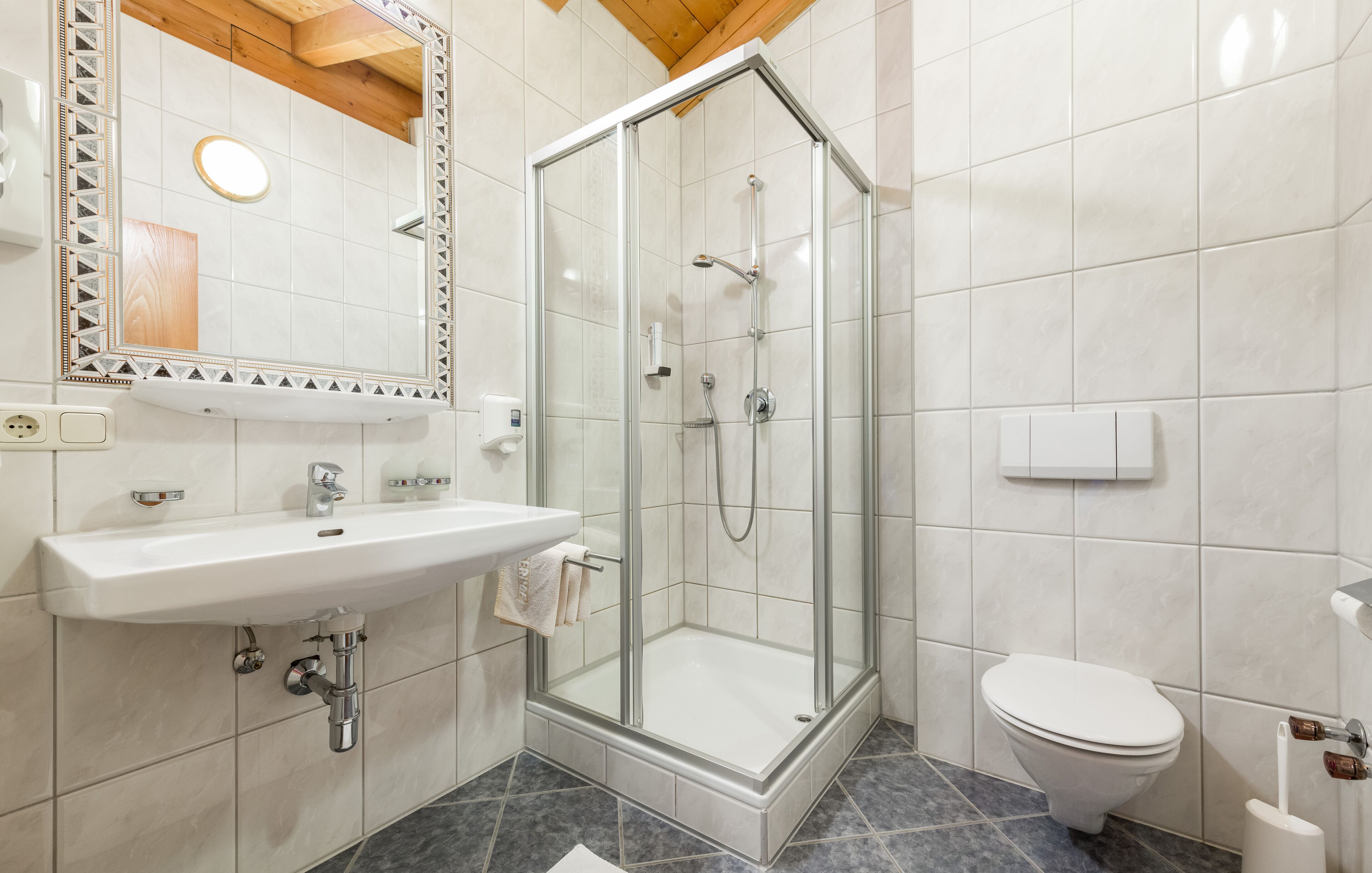 Un bagno moderno con doccia vetrata, lavandino bianco e water.