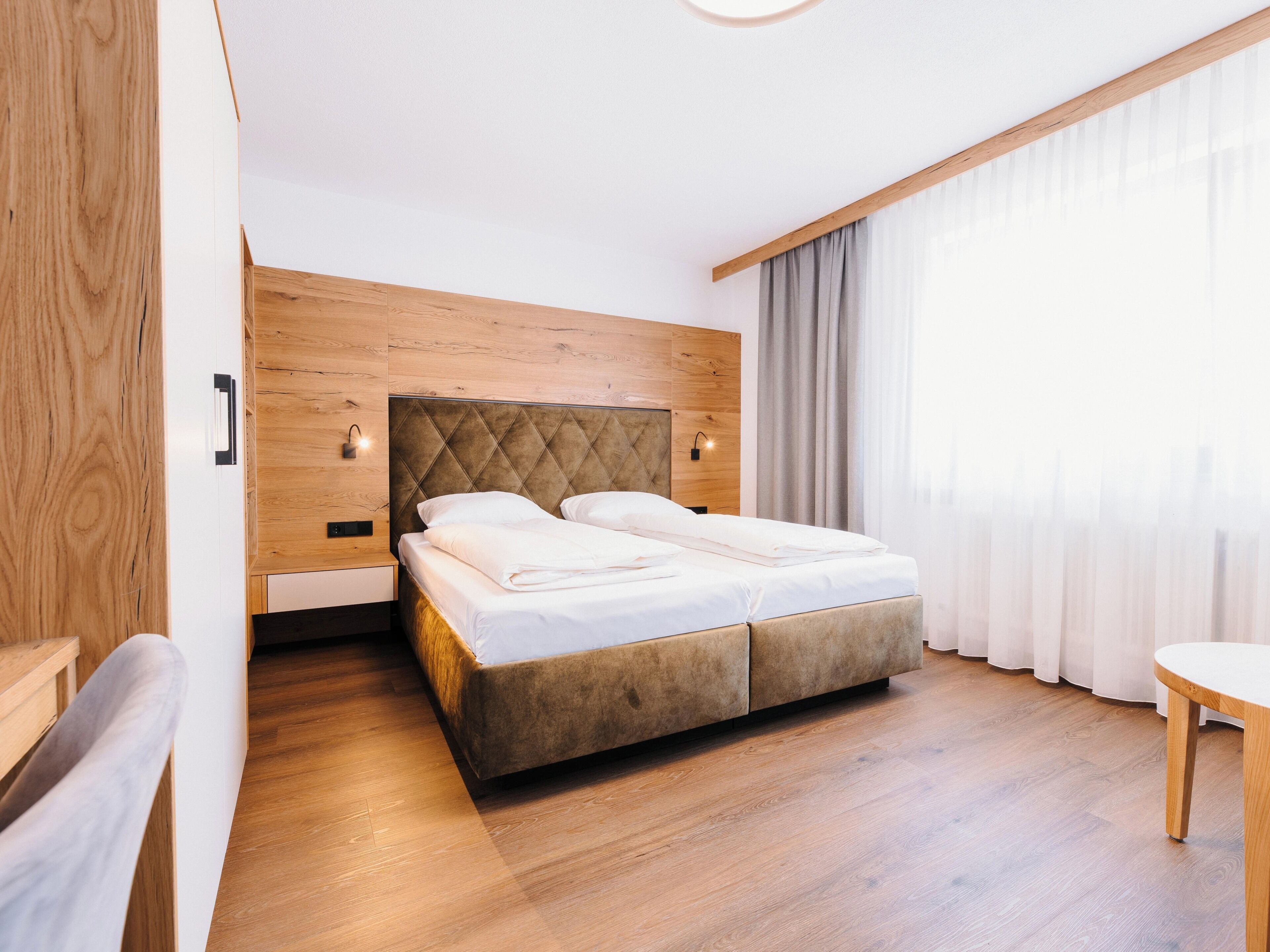 A double bed with a wooden headboard in a hotel room.