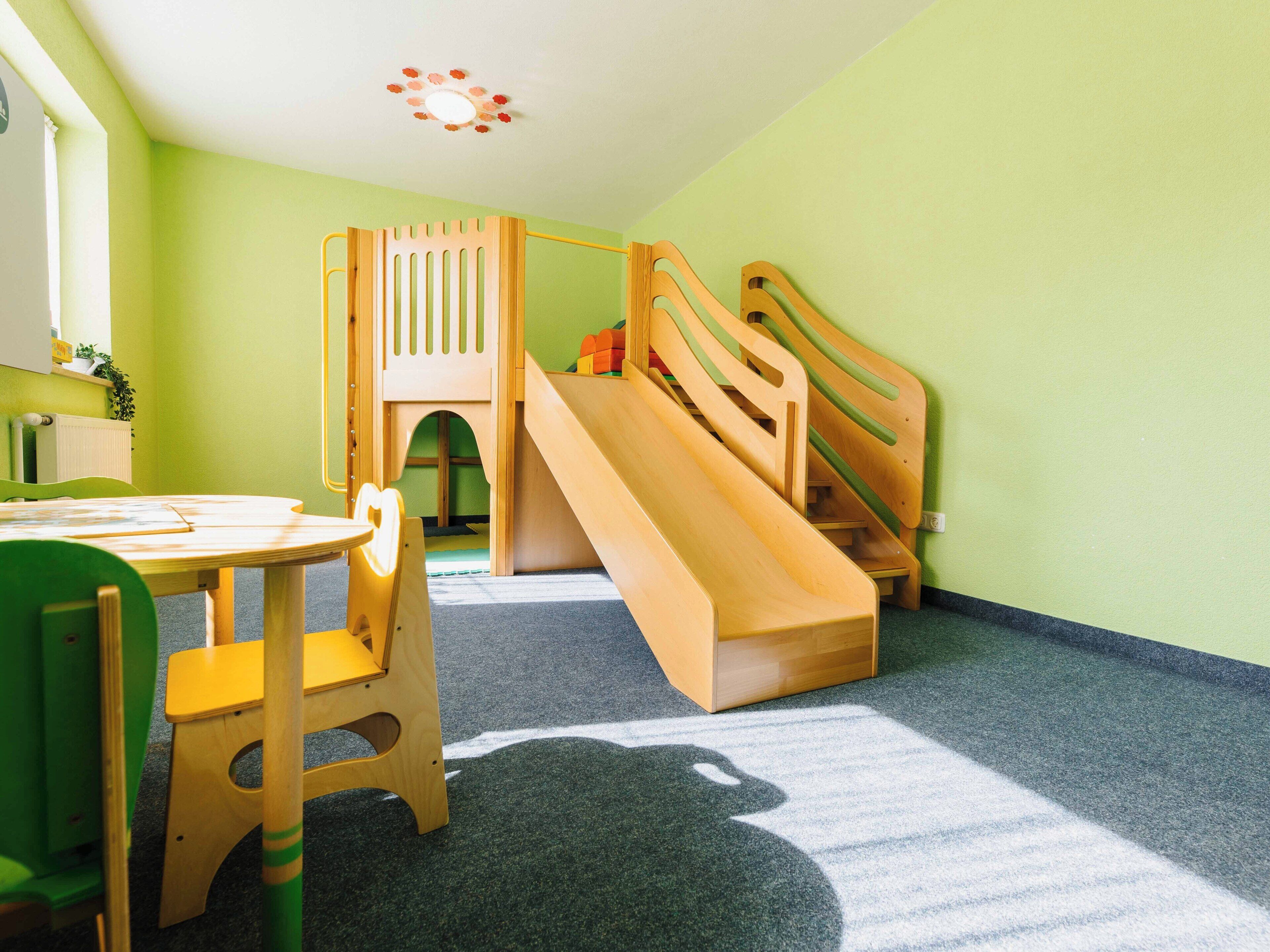 A children's play area with a slide and a table with chairs.
