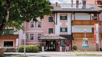 A hotel with a traditional architectural style, featuring a tiled roof and a balcony.