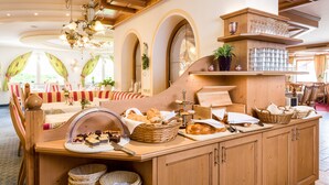 Un buffet de petit-déjeuner proposant diverses pâtisseries, un coin café et une présentation de verres à vin.