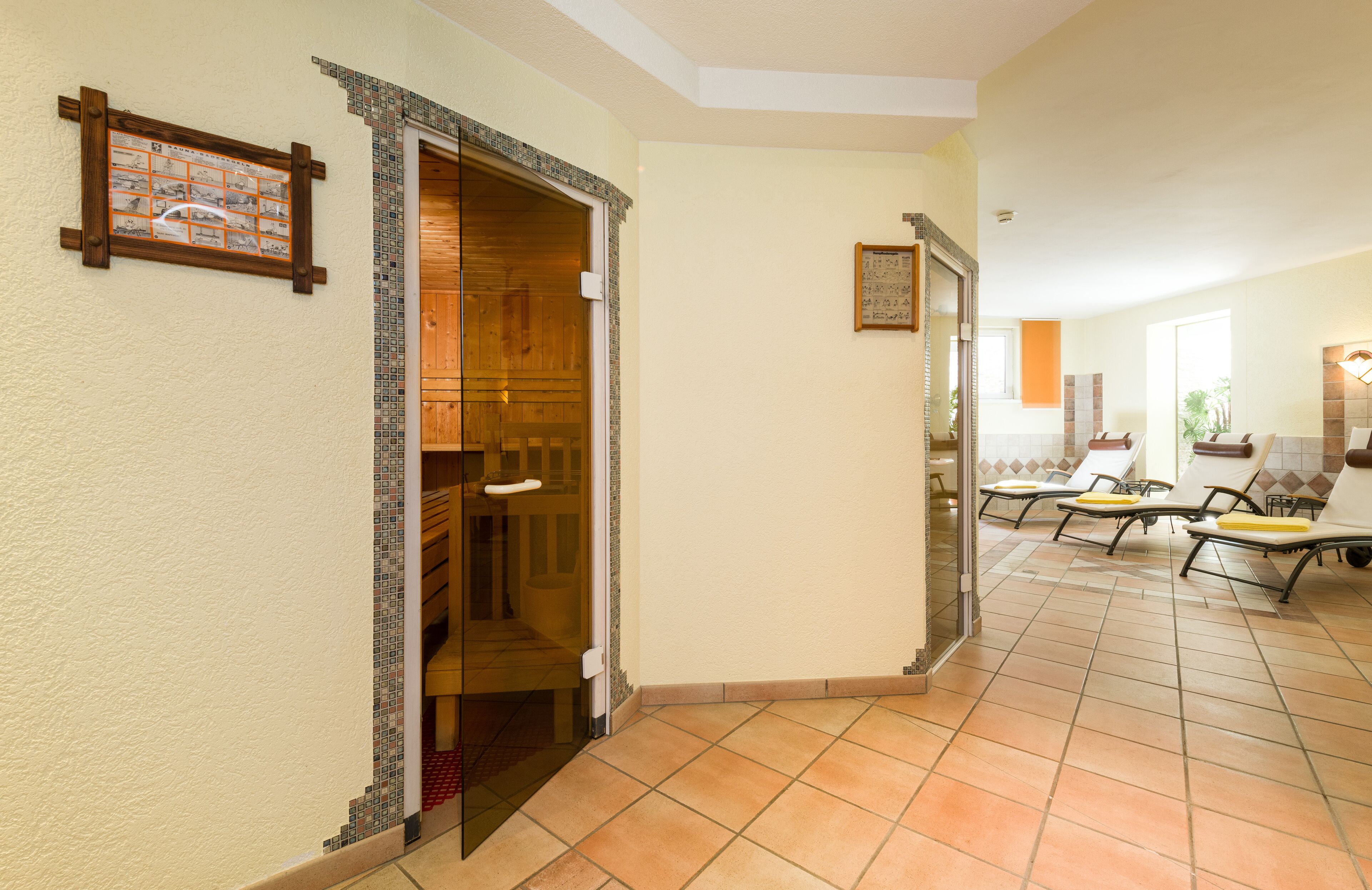 Un hall de hotel con suelo de baldosas, mostrador de recepción de madera y zona de estar con sillones.