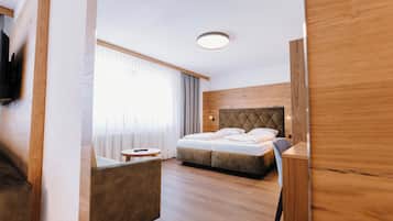 Una habitación de hotel moderna con una cama grande, una pequeña mesa redonda y un espacio para sentarse.