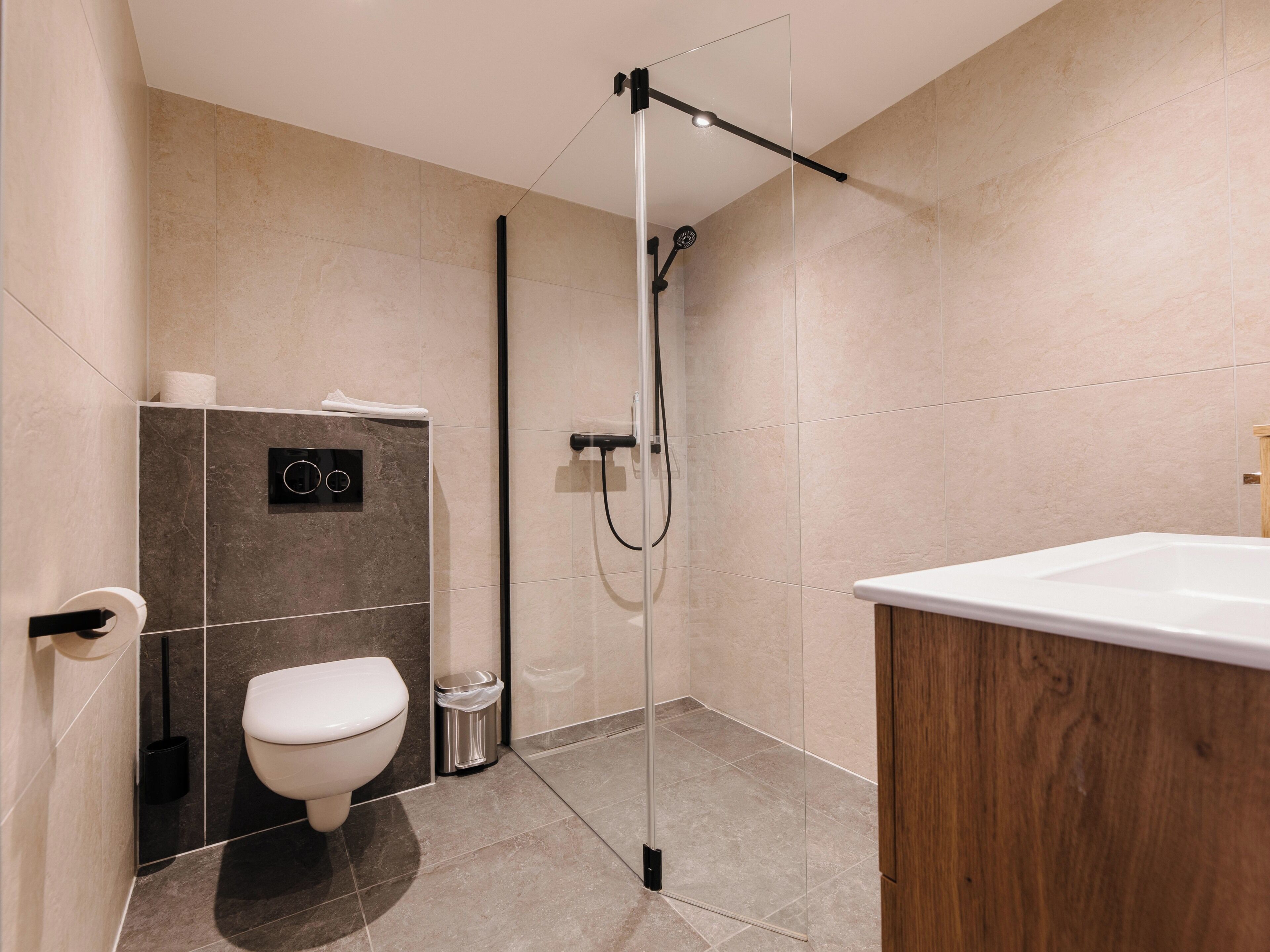 A modern bathroom with a toilet, bidet, and shower.