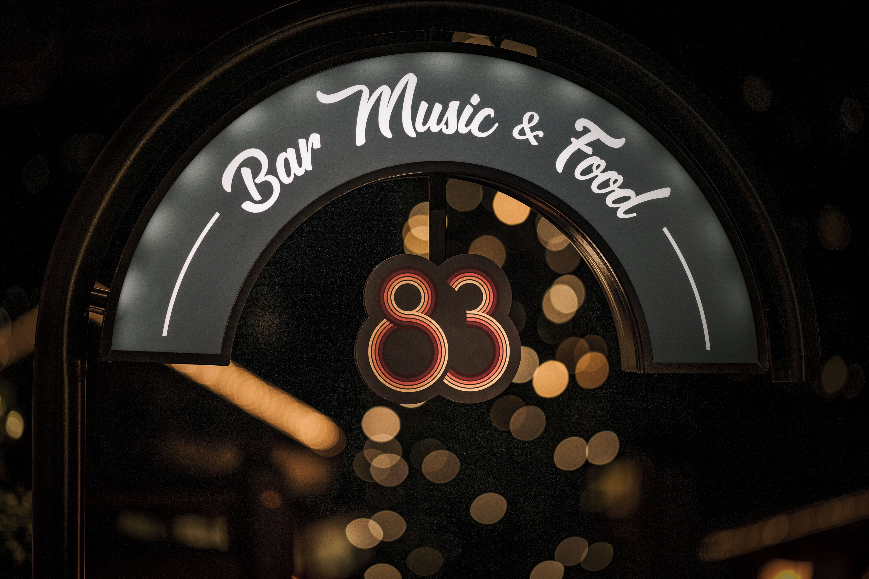 A sign with the text "Bar Music & Food" and the number "83".