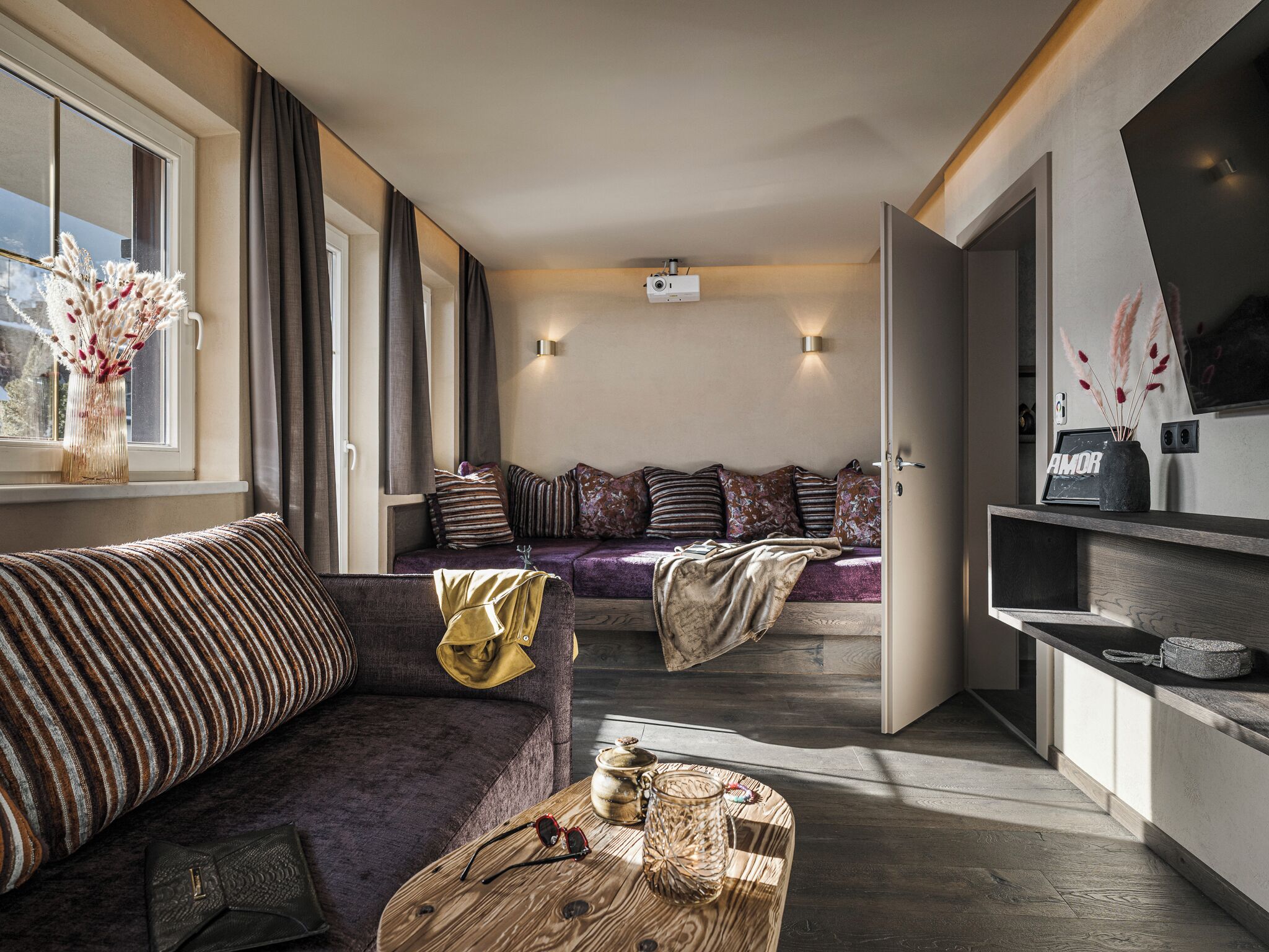 Ein modernes Wohnzimmer mit einer Couch, einem Couchtisch und einem Essbereich mit einem Fernseher.