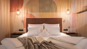 A hotel room with a large bed, two bedside tables, a wall-mounted light fixture, and a decorative wall panel.