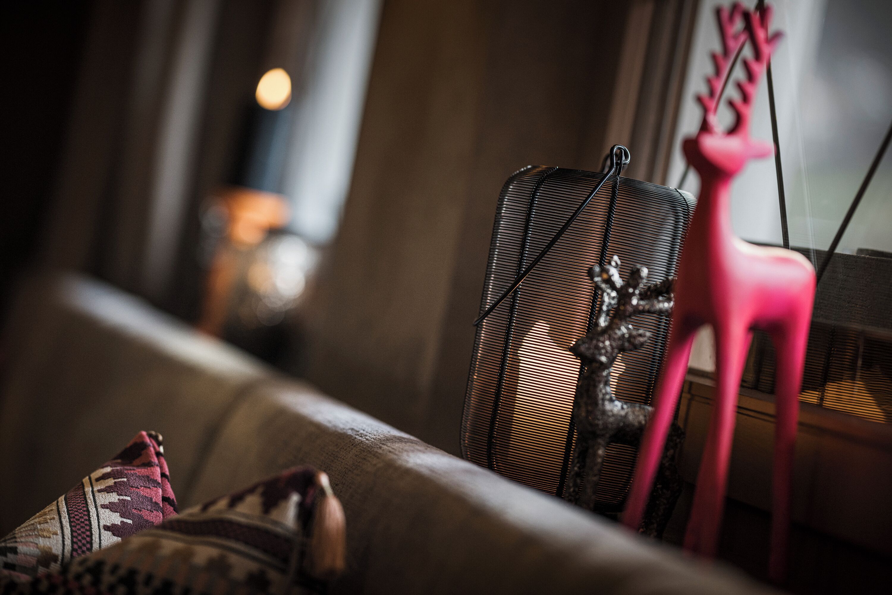 A close-up of a sofa with patterned cushions and a decorative deer figurine.