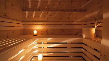 A sauna with wooden benches and a central light source.