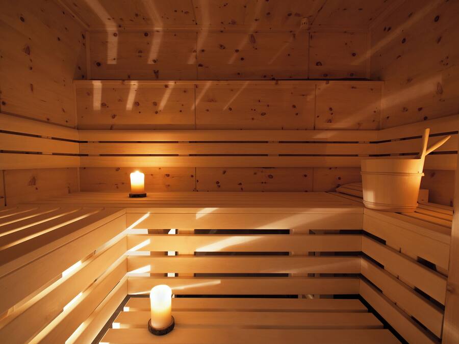 A sauna with wooden benches and a central light source.