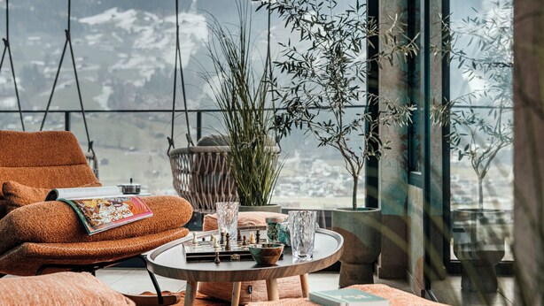 A cozy seating area with a view of a snowy landscape. - Hotel Sieghard (Schwendau)