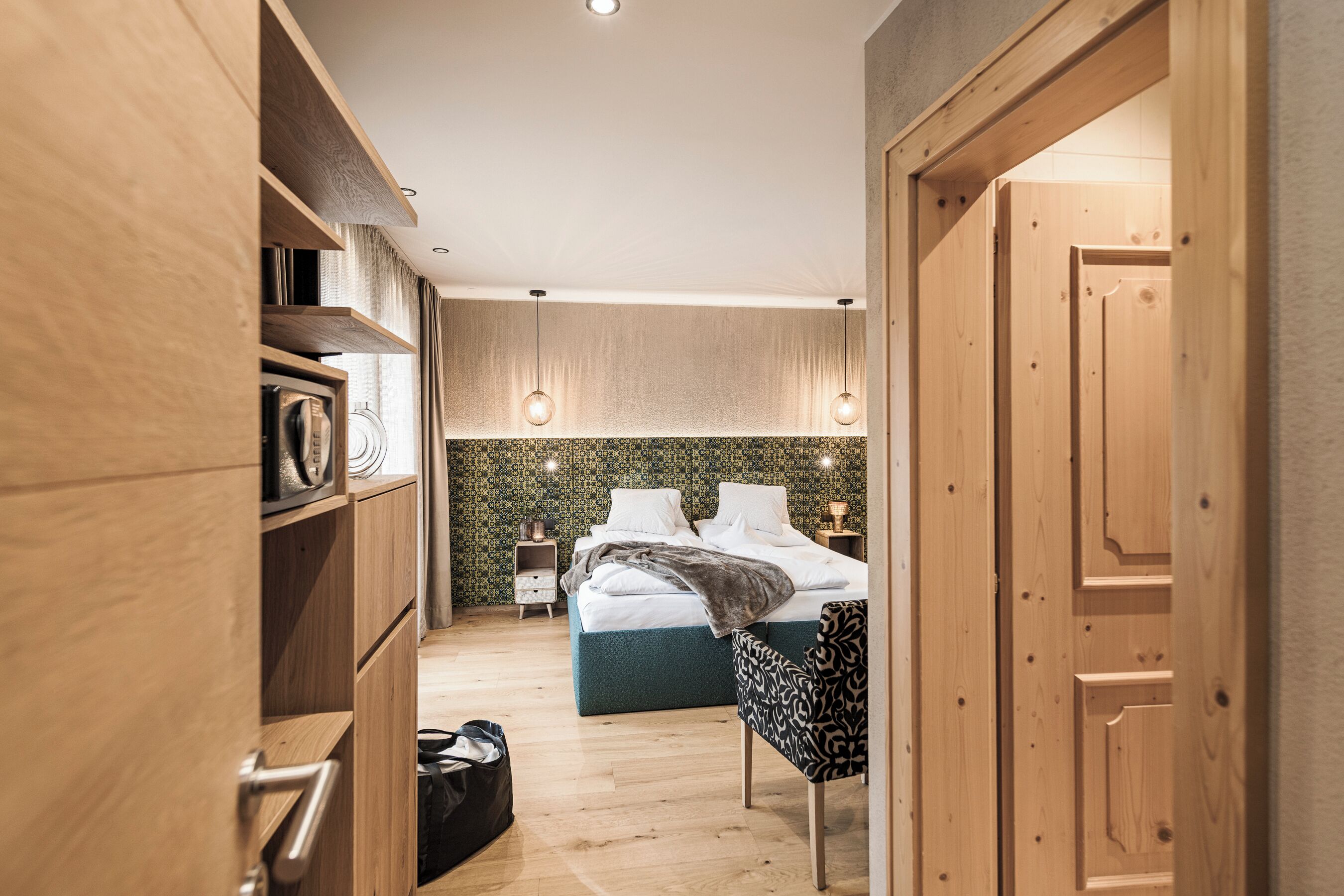 A bedroom with a bed, bedside tables, a wardrobe, and a chair.