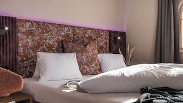Una habitación de hotel con una cama, una mesita de noche y una silla.