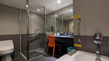 Un baño moderno con ducha de vidrio, inodoro, lavamanos con espejo y bañera.