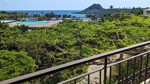 A view of a lush green landscape with a pool area and a distant mountain. - Howard Beach Resort Kenting (Hengchun)