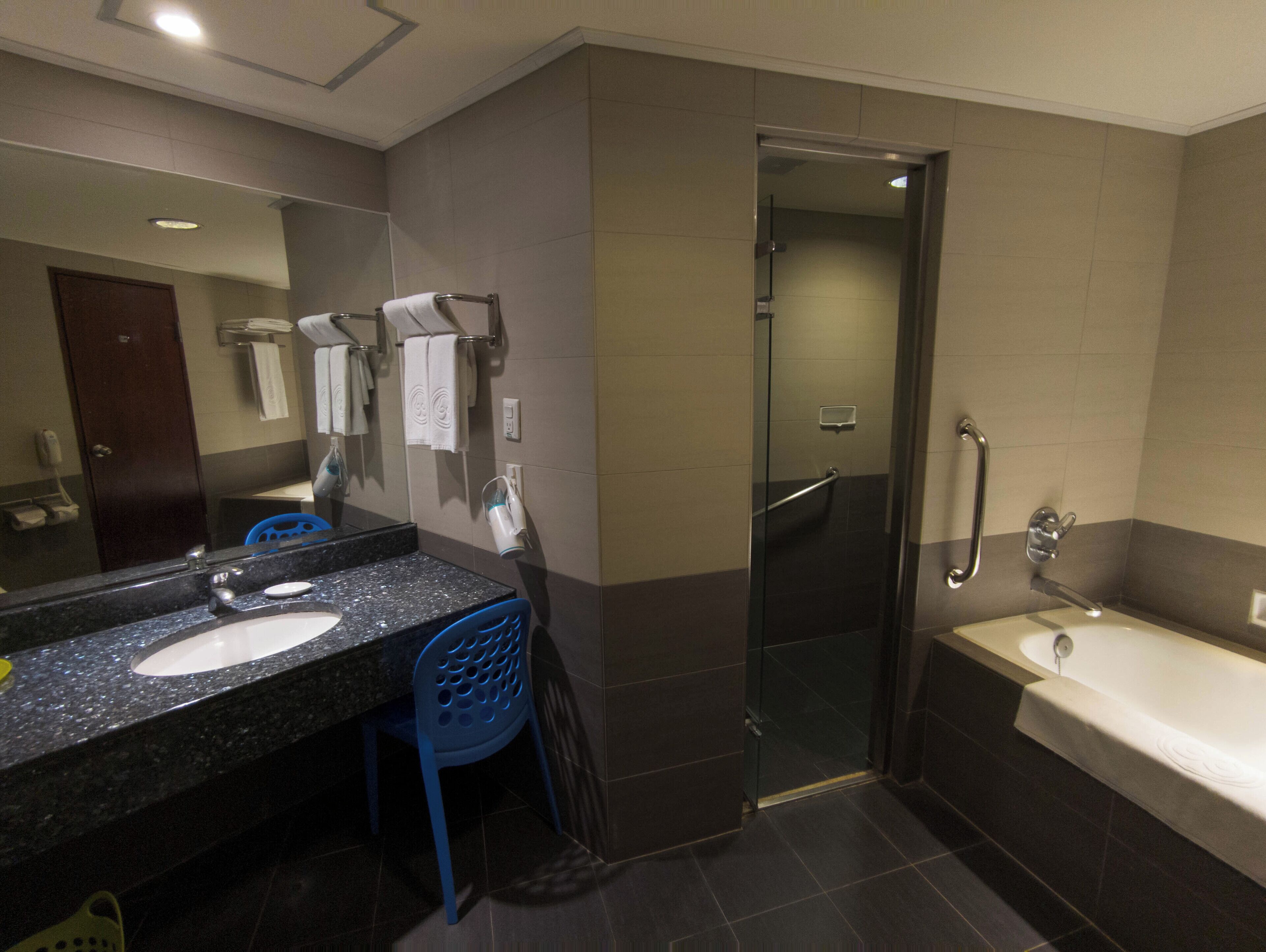 A modern bathroom with a double sink, a glass shower enclosure, and a bathtub.