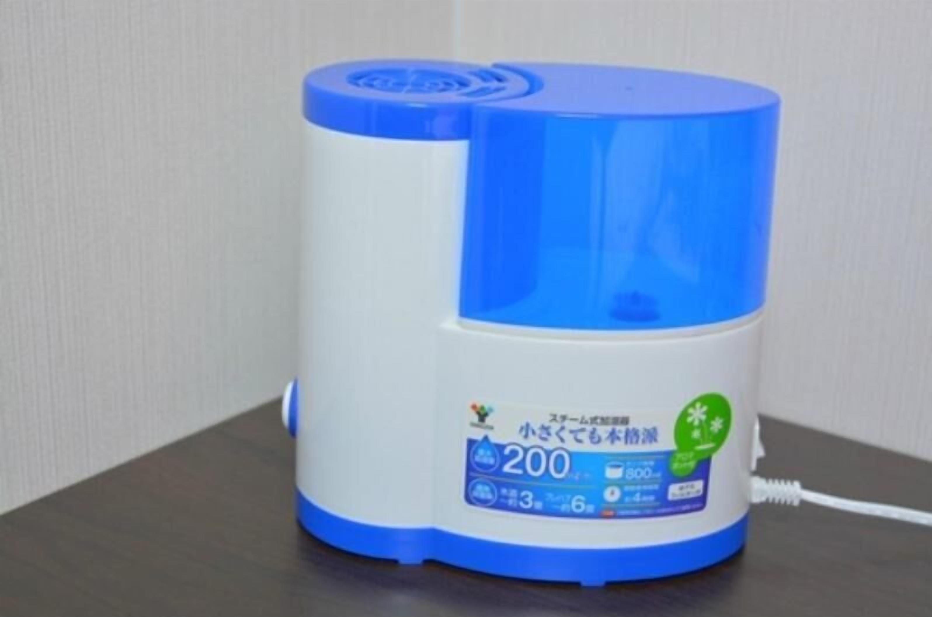 A cylindrical device with a blue top and white body, featuring a label with Japanese text and a green icon.