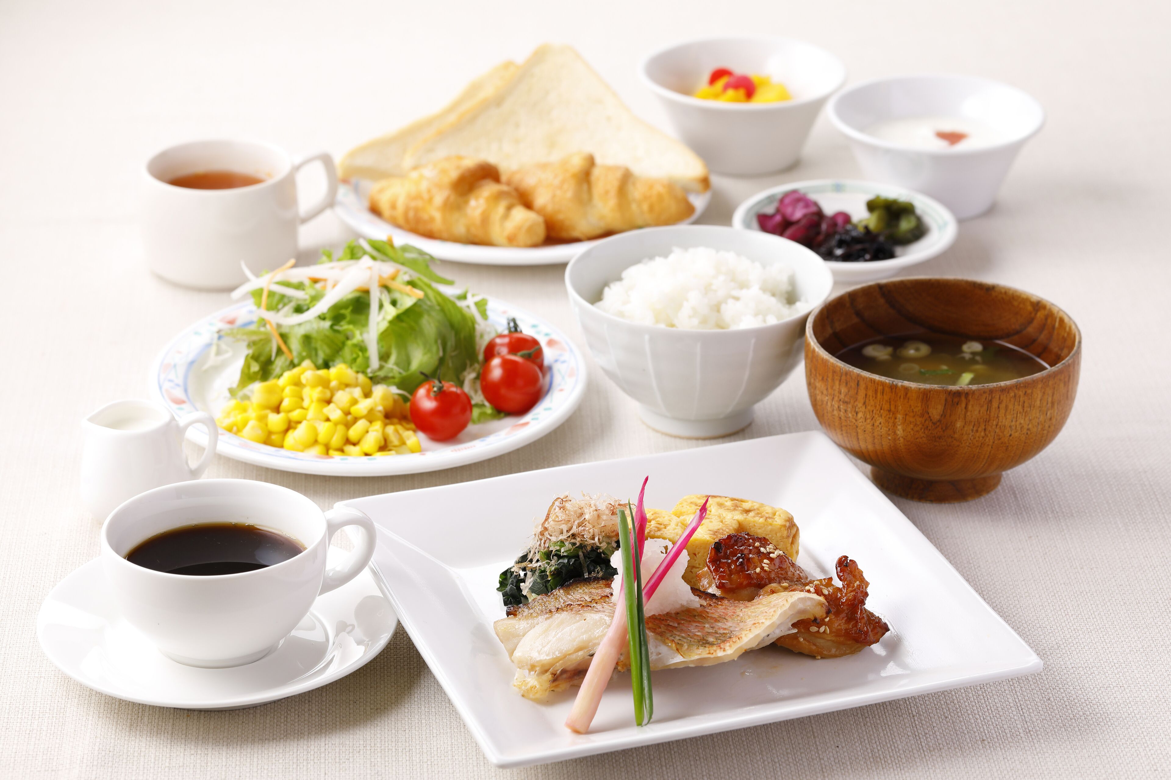 A variety of dishes including rice, salad, and soup, arranged on a table.