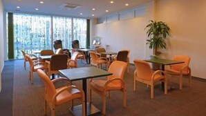 A conference room with multiple tables and chairs, large windows with blinds, and a potted plant. - Value The Hotel Sendai Natori (Natori)