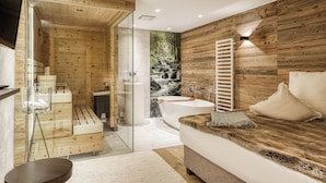 Ein modernes Badezimmer mit einer Holzvertäfelung, einer Badewanne und einer Duschkabine aus Glas.