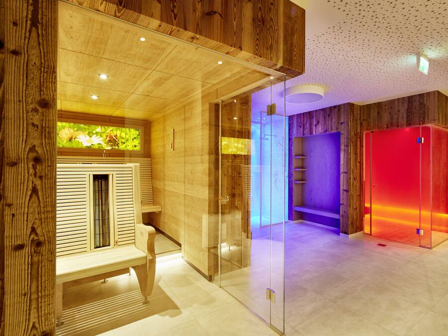 Un espacio de spa moderno con paneles de madera, ducha con cerramiento de vidrio y un armario rojo.