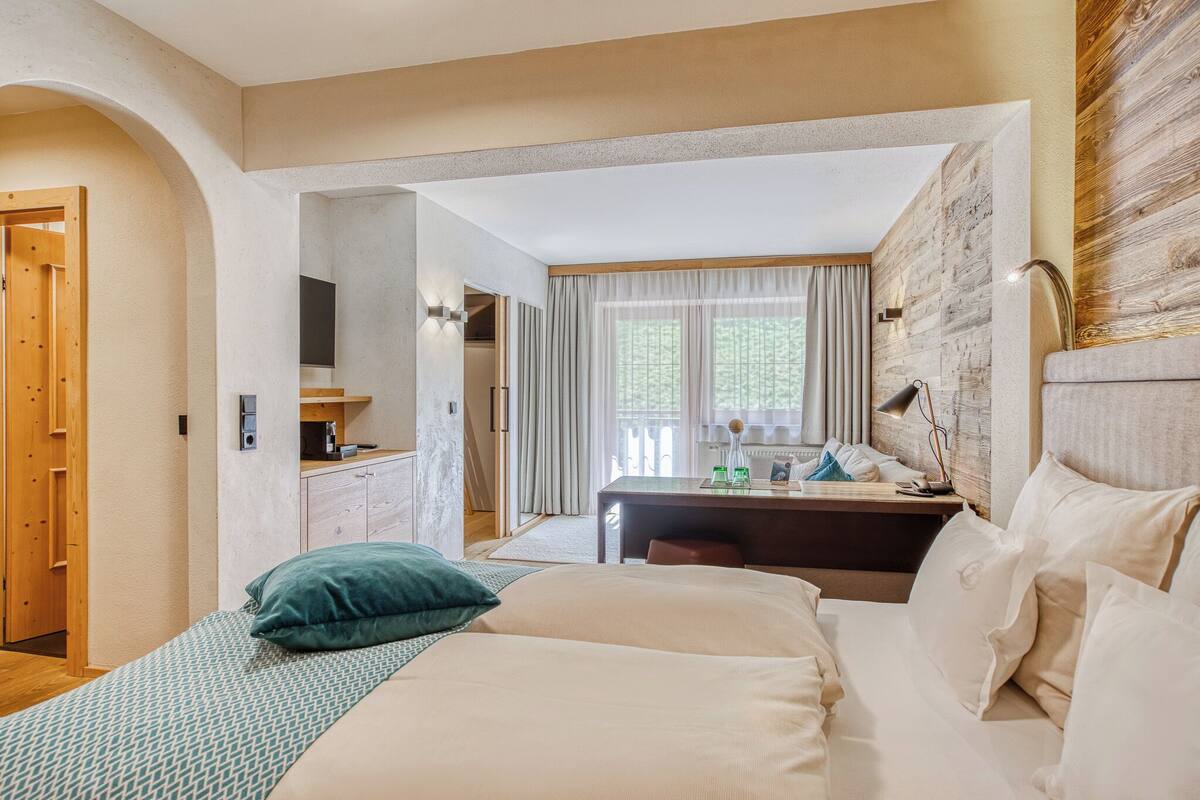 Ein Hotelzimmer mit Bett, Schreibtisch und Blick ins Freie.