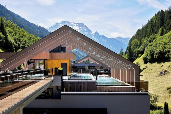 A modern building with a pool and a view of mountains. - ZillergrundRock Luxury Mountain Resort (Mayrhofen)