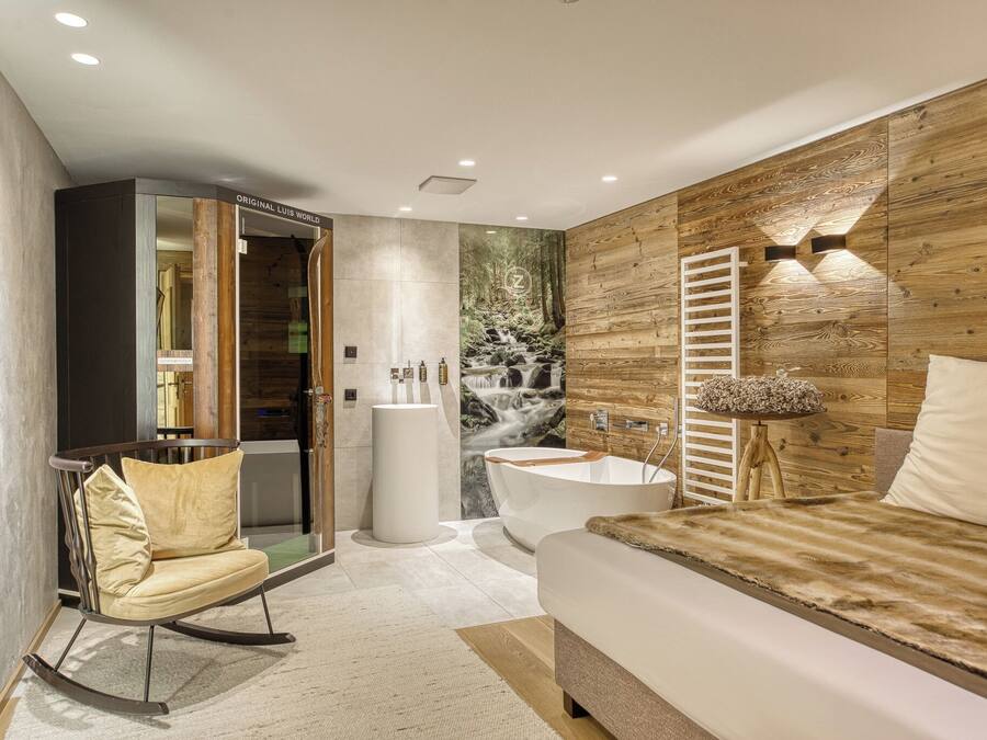 Un baño moderno con una bañera independiente, un tocador de madera y un espejo grande.