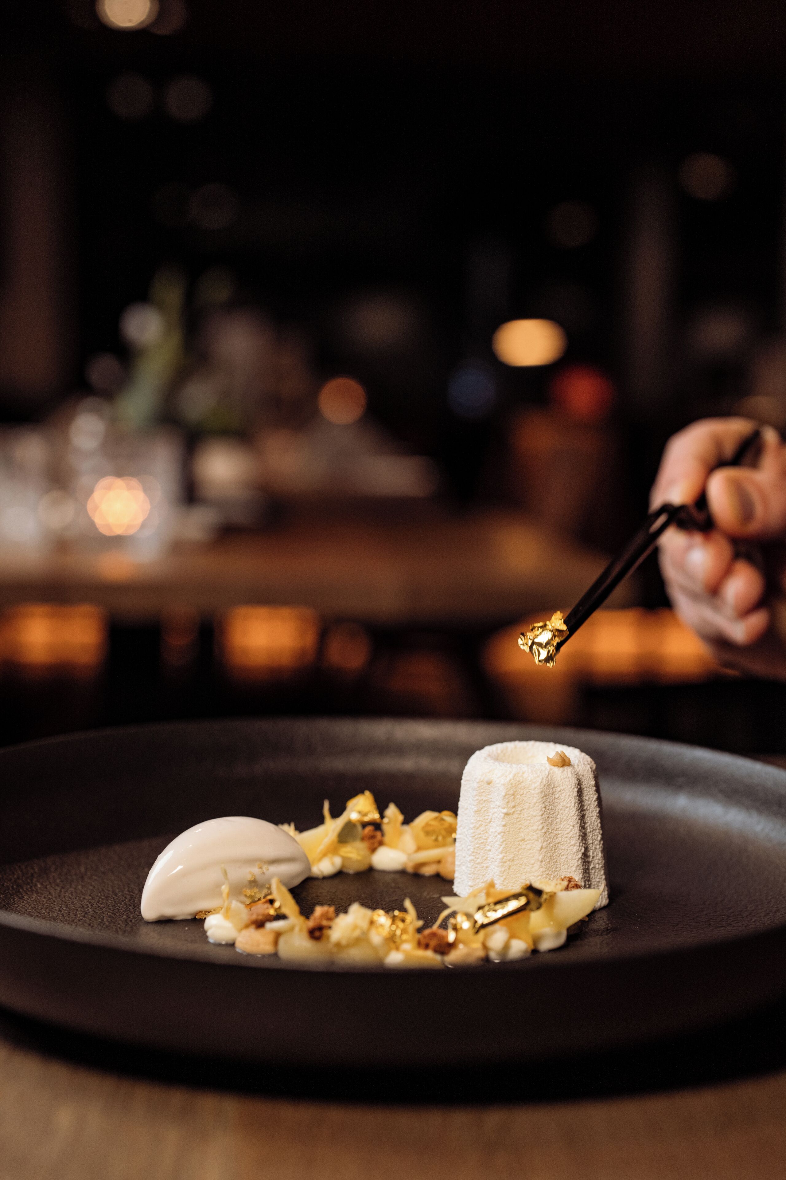 A dessert on a black plate with a spoon.